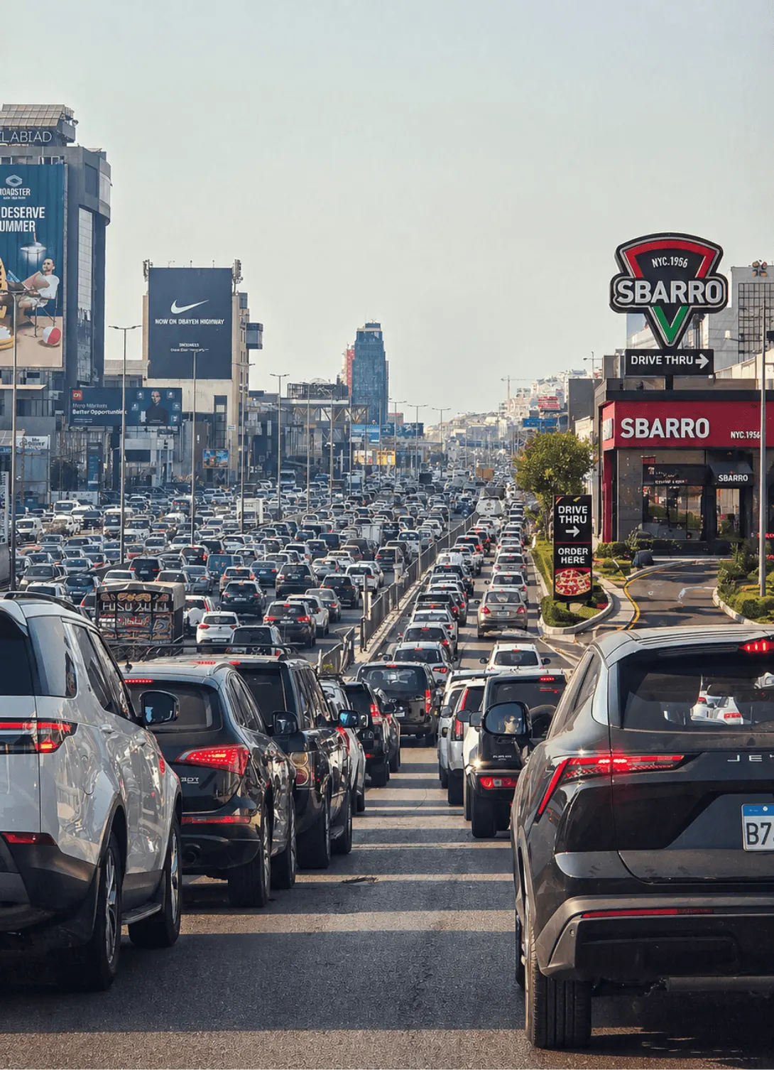 Sbarro billboards rising above heavy traffic on the Dbayeh highway.